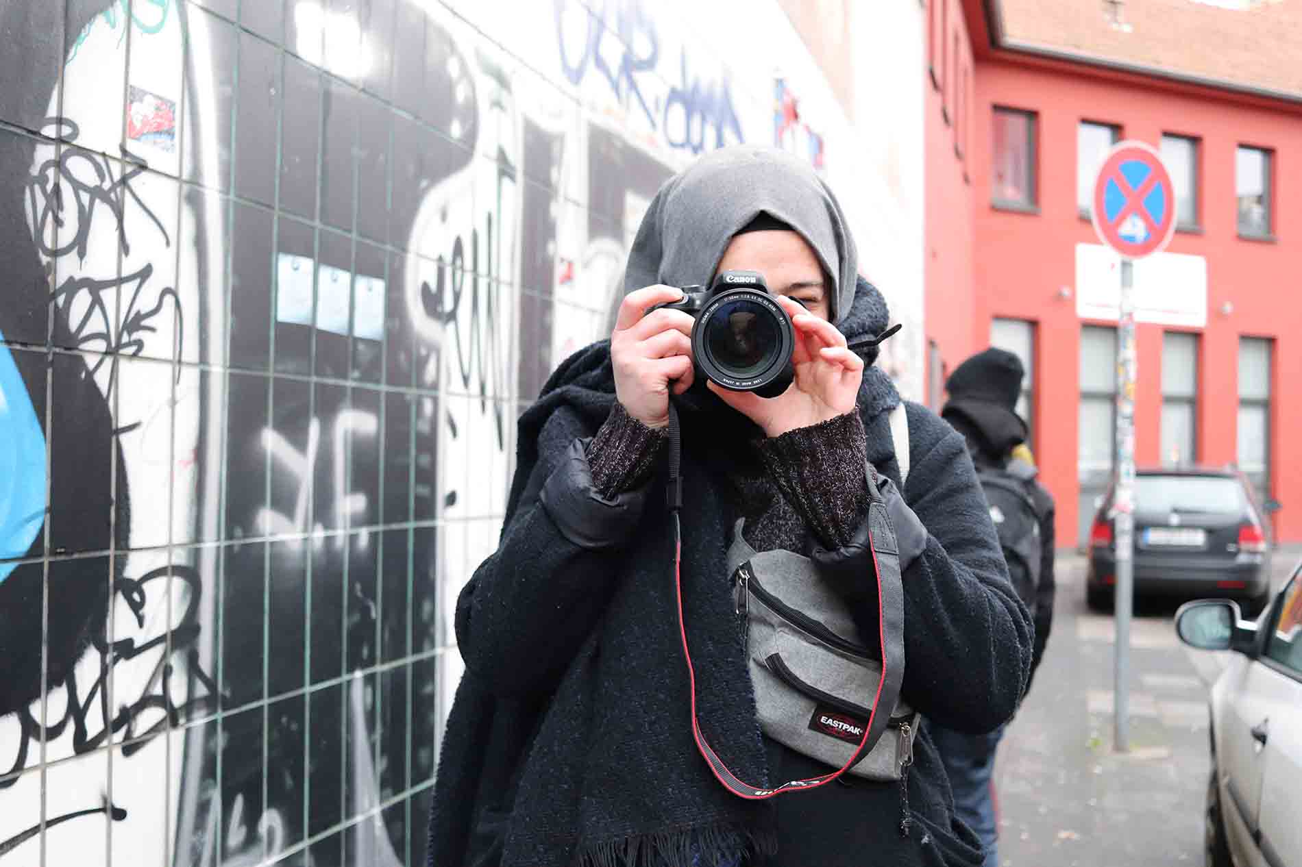 Mädchen mit Kopftuch beim Fotografieren