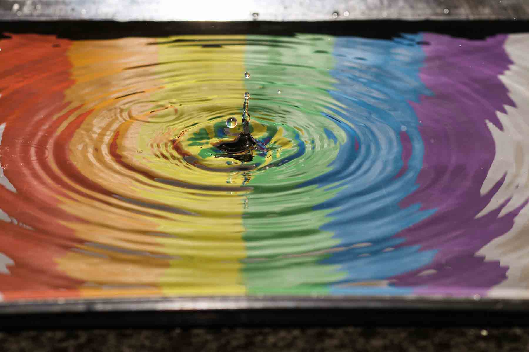 Regenbogenfarben reflektiert auf einer Wasserpfütze